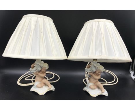 A pair of Schau Bach Kunst, Germany porcelain cherub lamps. 20cms to light fitting, 17cms with shades.Condition ReportGood co