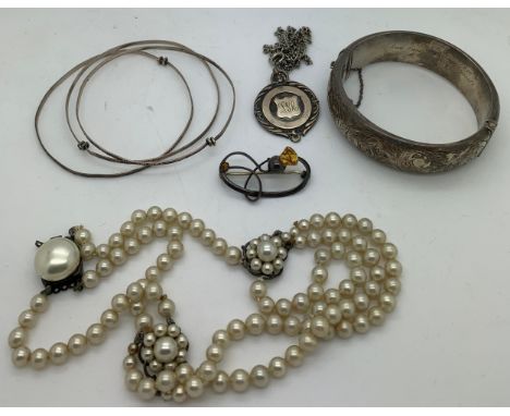 Jewellery to include a hallmarked silver bangle, a hallmarked silver medal on a white metal chain, a simulated pearl necklace