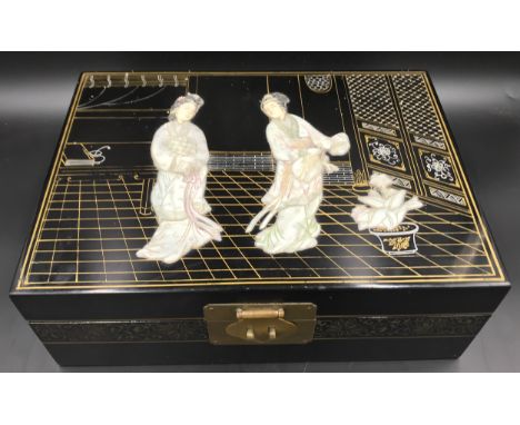 A Japanese black lacquered jewellery box with a mother of pearl lid decorated with Geisha girls and a fitted tray interior. 3