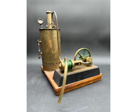 Vertical stationary reciprocating steam engine model, consisting of a Brass boiler that powers a flywheel, mounted on a woode
