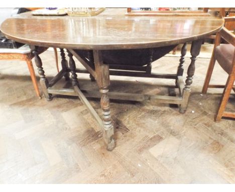 Large antique oak gate leg dining table of oval form 153cm wide 