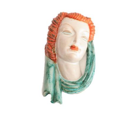 An Art Deco Goldscheider Pottery Wall Mask, model No.7883, of a woman, glazed in colours, printed, painted and impressed mark