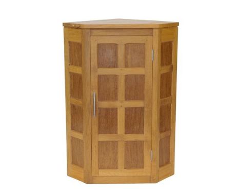 Workshop of Robert Mouseman Thompson (Kilburn): An English Oak Panelled Hanging Corner Cupboard, 2000, with contrasting fumed