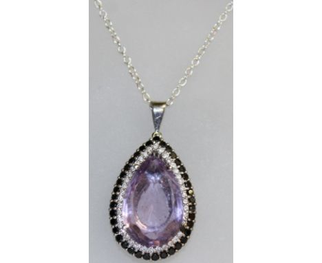 A SUPERB 18CT WHITE GOLD SET PEAR SHAPED AMETHYST PENDANT surrounded by black and white diamonds.