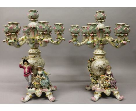 A PAIR OF "DRESDEN" PORCELAIN SEVEN LIGHT CANDELABRA with six scrolling branches, gallant and young lady to the base. 1ft 8in