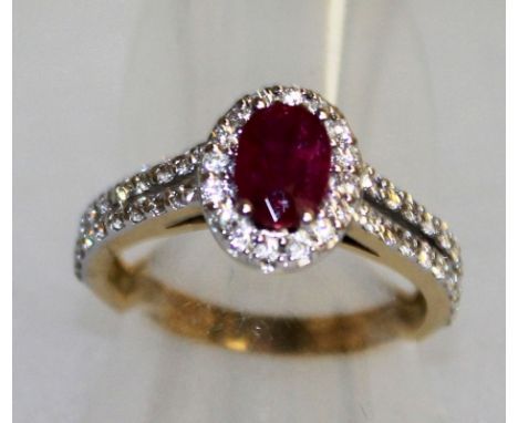 A RUBY AND DIAMOND CLUSTER RING, with double line shoulders, set in 18ct white gold.