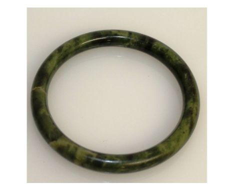 A GREEN JADE CIRCULAR BANGLE. 8cms diameter.