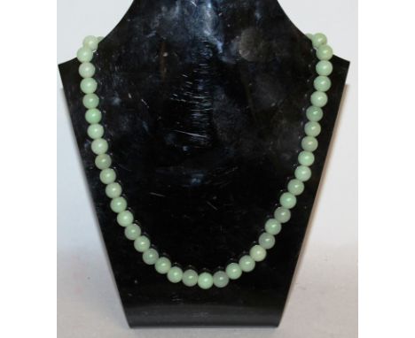 A GOOD JADE NECKLACE with 55 graduated stones.