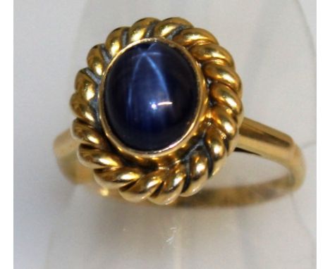 A GOOD STAR SAPPHIRE CABOCHON RING set in yellow gold.