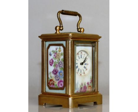 A MINIATURE FRENCH BRASS AND PORCELAIN PANEL CARRIAGE CLOCK with floral porcelain panels. 2,5ins high.