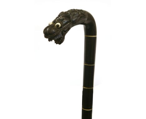 A South East Asian horn walking stick,c.1880, the terminal carved with a dragon,82cm long