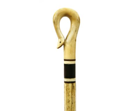 A marine ivory and whalebone walking stick,the snake's head handle over three baleen discs and an octagonal and plain taperin