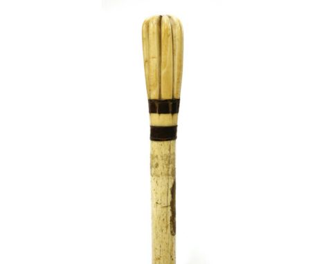 A marine ivory and whalebone walking stick,with an elongated eight segment handle, two baleen discs over a plain shaft, remna