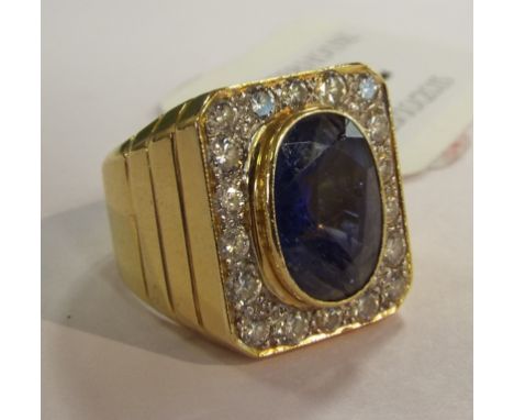 A sapphire and diamond ring, the large oval cut sapphire within a diamond halo, in a yellow and white coloured metal mount