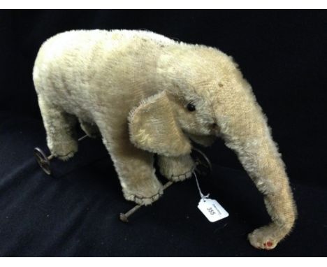 A vintage plush pull-along toy elephant on five-spoke wheels, possibly Steiff 