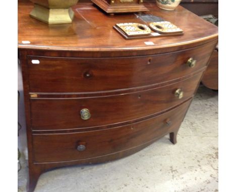 A George III mahogany bowfront chest of three long drawers on splay bracket feet