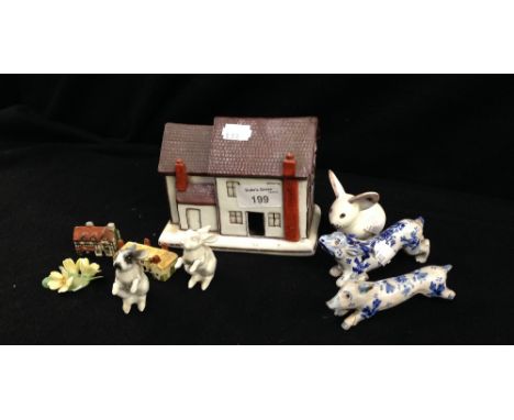 A porcelain model of a half-timbered cottage, two tin-glazed animal knife rests and other similar ornaments