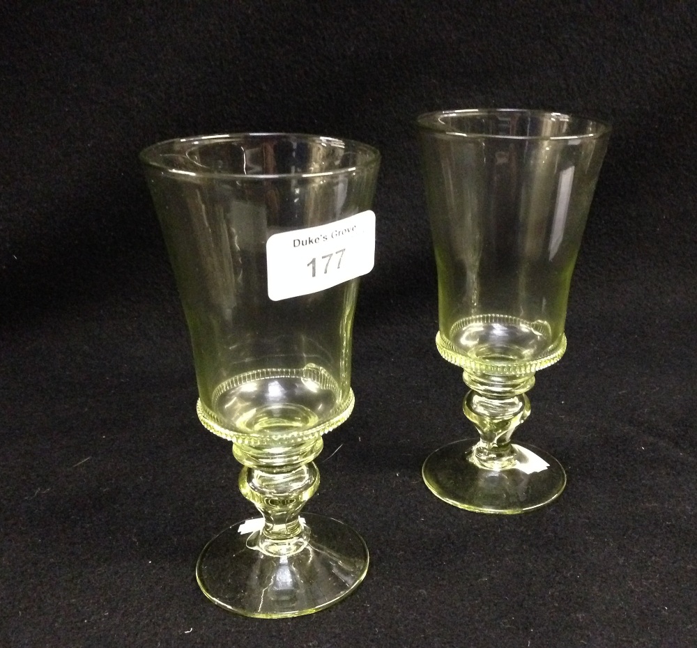 A pair of pale green glass Italian style wine glasses with straight