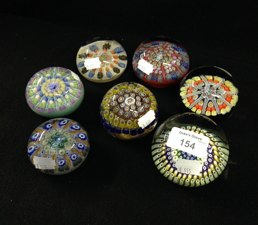 A collection of glass paperweights including a weight with radiating