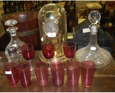An anniversary clock, a cut-glass ships decanter, another similar and a collection of cranberry glasses