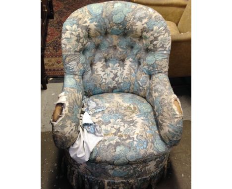 A Victorian button-back armchair on turned legs
