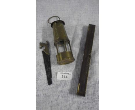 A miniature miners lamp, spirit level and miniature carpenter's saw