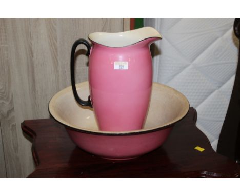 An early 20th century pink and black glazed pottery wash jug and basin