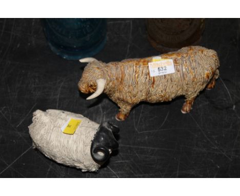 A pottery model of a Highland cow, with chip to ear, and a similar model black faced ram (chip to horn).