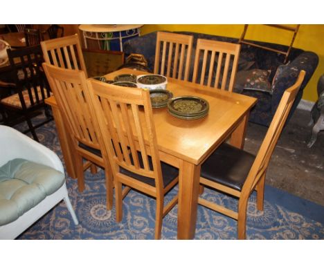 A modern light oak extending dining table and six chairs 