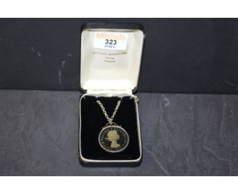 A white metal enamelled coin pendant and chain