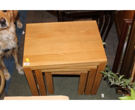 A nest of three light oak occasional tables, largest 52 cm high x 55 cm wide x 40 cm deep 
