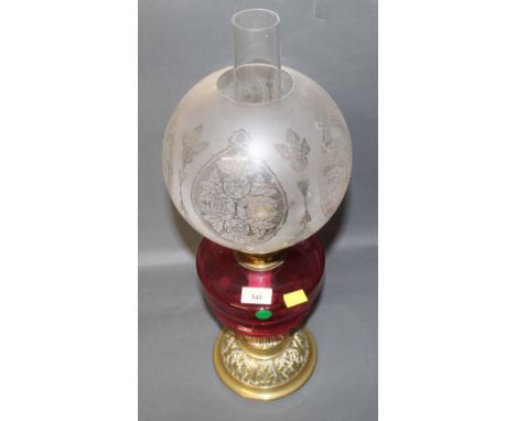 A Victorian brass and glass oil lamp, with etched globular shade and cranberry glass reservoir.