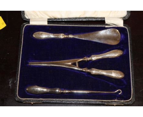 A silver mounted and cased shoe horn and button hook and glove stretcher 