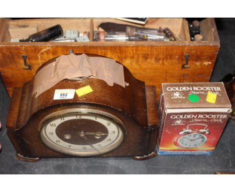 A 1930's oak mantle clock with key and a boxed golden rooster alarm clock.