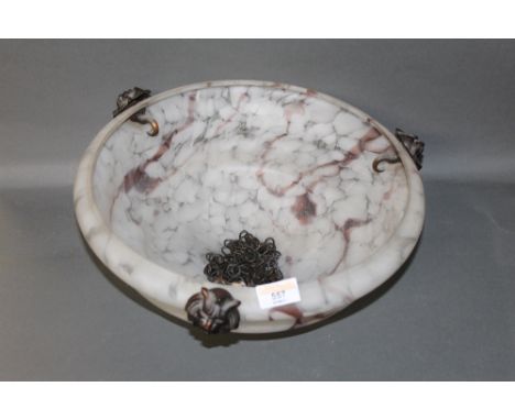 A mottled glass lamp shade with coppered lion mask mounts.