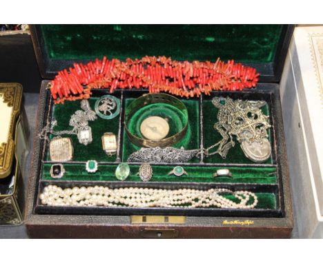 An early 20th century brown leather jewellery box, the green velvet lined interior with lift out tray, containing a selection