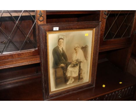 An Edwardian photographic print of a married couple on their wedding day within oak frame and glazed.