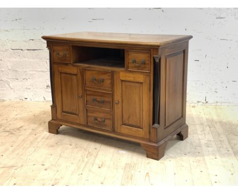 A French Empire style mahogany side cabinet, the moulded top over two drawers and an open shelf, above three further drawers 