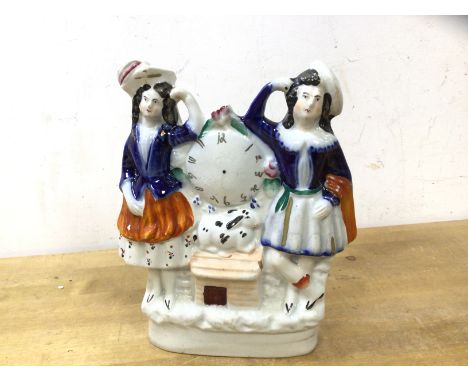A Staffordshire flatback figure Poor Man's Clock, two figures flanking clock dial above rabbit and hutch, (19cm high)