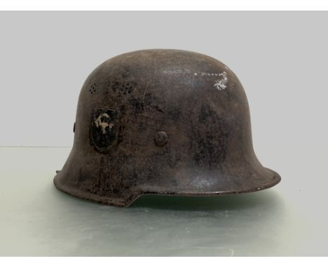 A WWII German Luftscutz helmet in black paint with decals to each side, leather helmet liner