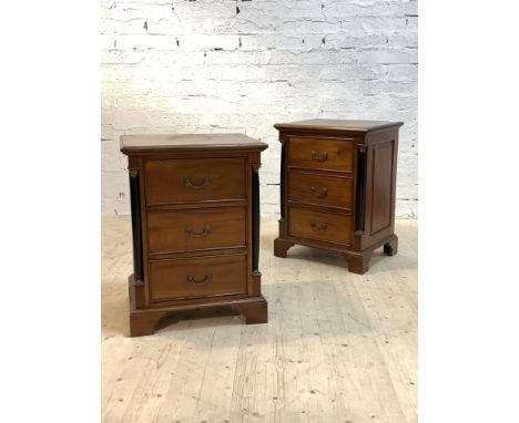A pair of French Empire style mahogany chests, each with moulded tops over three drawers flanked by ebonised pilasters with m