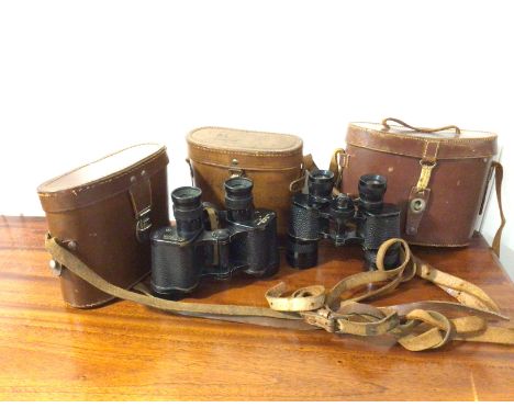 A pair of binoculars inscribed Taylor - Hobson 1943, with broad arrow, a pair of binoculars and three travelling cases (a lot