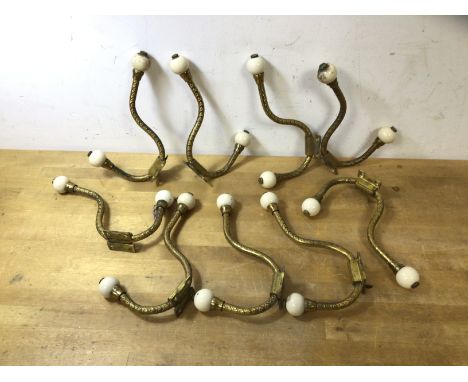 A set of nine Victorian gilt and ceramic wardrobe hooks, (18cm)