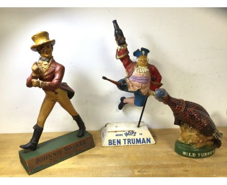 A group of alcohol mascot items including Johnny Walker, polychrome composition figure, (41cm h), a Moorhops in Ben Truman an