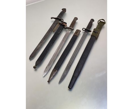 A British 1887 sword bayonet in later steel scabbard, a Spanish M1893 long artillery bayonet, a British 1907 pattern bayonet 