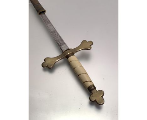 A brass hilted masonic sword with faux ivory handle, etched blade, leather scabbard with brass fittings (86cm)