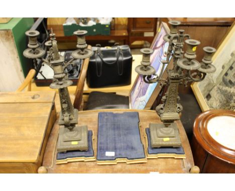 A pair of 19th Century brass clock garnitures raised on plinths; together with one other plinth 