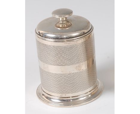 A late Art Deco silver cylindrical table cigarette dispenser, the undecorated cover with rise-and-fall action over body decor