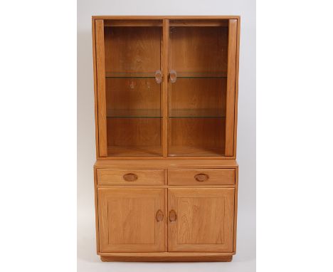 Ercol - A contemporary blond elm display cabinet, having twin glazed upper doors with adjustable shelves, over twin frieze dr
