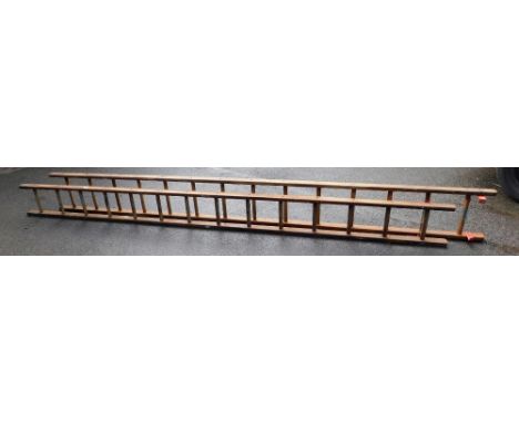 A wooden extending ladder, extension height approx 700cm.